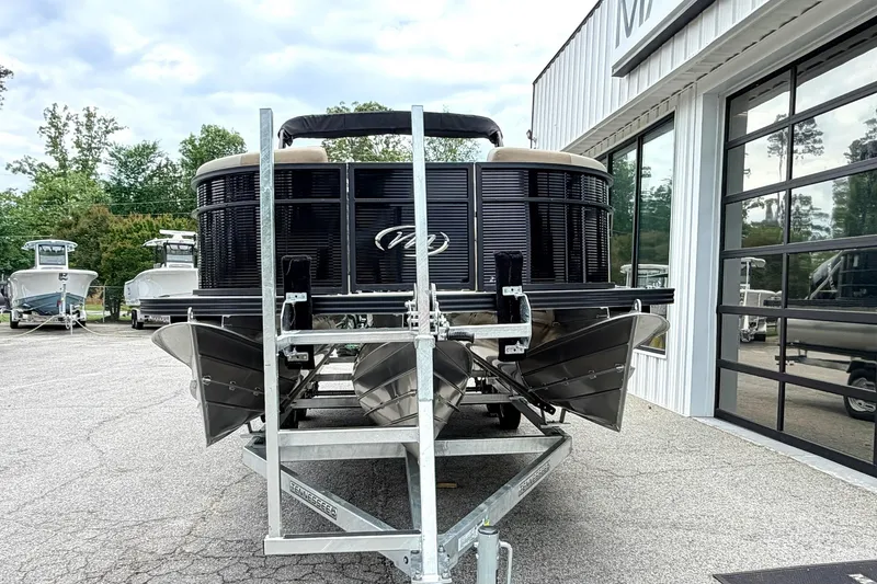 Slide: The Image of 2026 Manitou Aurora RF 23 pontoon boat on trailer, parked outside dealership. - 4