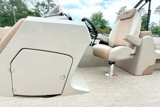 Slide: The Image of 2026 Manitou Aurora RF 23 boat interior with beige captain's chair and steering console. - 9