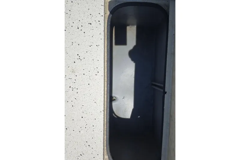 Slide: The Image of 2016 Xpress H20B Bay boat storage compartment, featuring a speckled interior surface. - 14