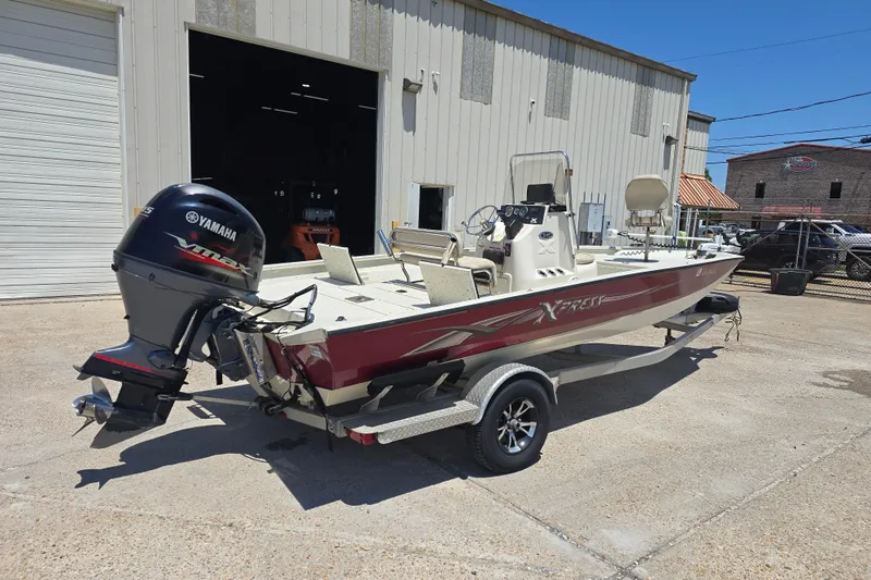 Slide: The Image of 2016 Xpress H20B Bay boat with Yamaha engine parked outside a garage. - 3