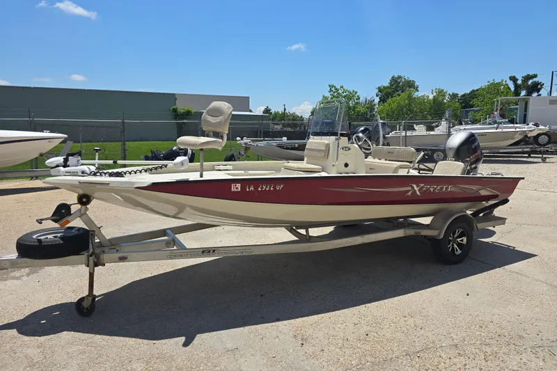 Slide: The Image of 2016 Xpress H20B Bay boat on trailer, parked outdoors under clear sky. - 7