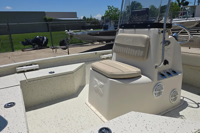 Slide: The Image of 2016 Xpress H20B Bay boat interior with seating and console, parked outdoors. - 8