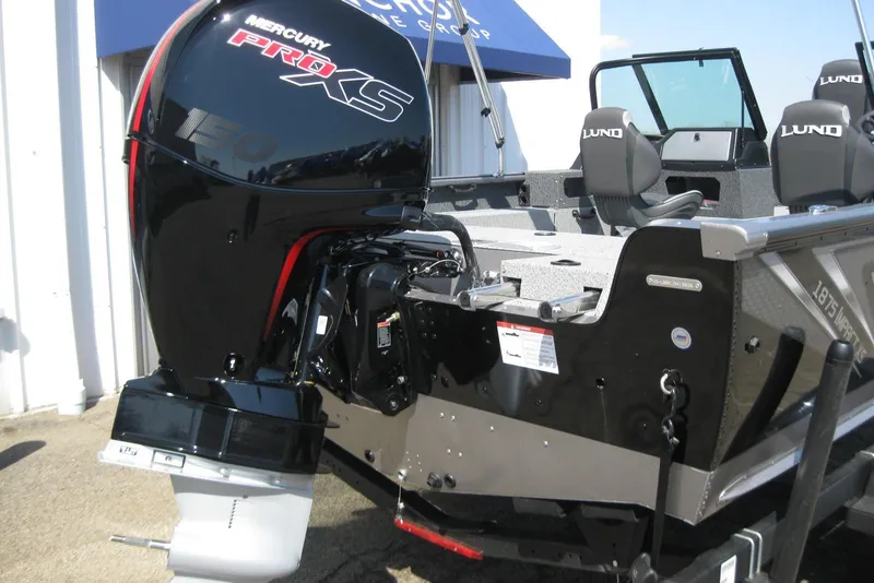 Slide: The Image of 2026 Lund 1875 Impact XS Sport boat with Mercury Pro XS engine, parked outdoors. - 13