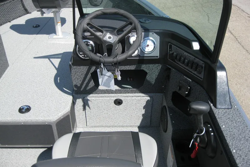 Slide: The Image of 2026 Lund 1875 Impact XS Sport boat cockpit with steering wheel and control panel. - 20
