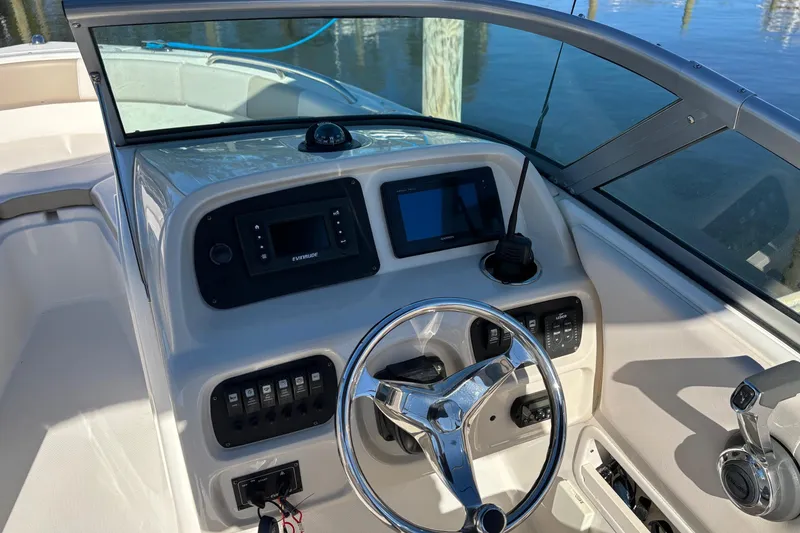Slide: The Image of 2017 Robalo R227 Dual Console boat dashboard with steering wheel and navigation controls. - 11