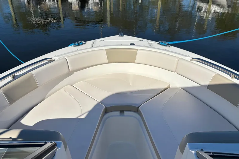 Slide: The Image of 2017 Robalo R227 Dual Console boat with spacious bow seating, docked on calm water. - 14