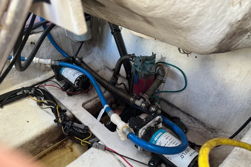 Slide: The Image of 2017 Robalo R227 Dual Console boat interior showing wiring and plumbing components. - 19