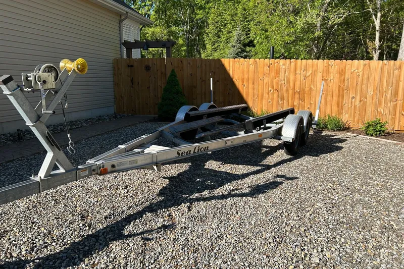 Slide: The Image of Trailer for 2017 Robalo R227 Dual Console on gravel driveway. - 24