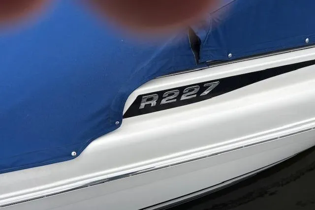 Slide: The Image of 2017 Robalo R227 Dual Console boat with blue cover on water. - 5