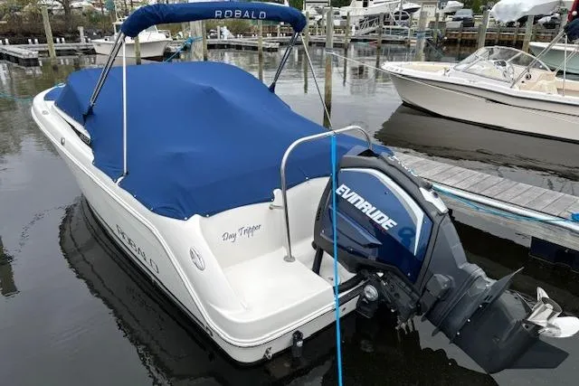 Slide: The Image of 2017 Robalo R227 Dual Console boat with blue cover and Evinrude motor docked. - 8