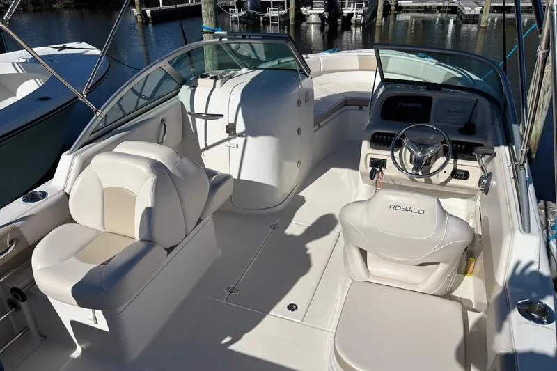 Slide: The Image of 2017 Robalo R227 Dual Console boat interior with white seating and steering wheel. - 9