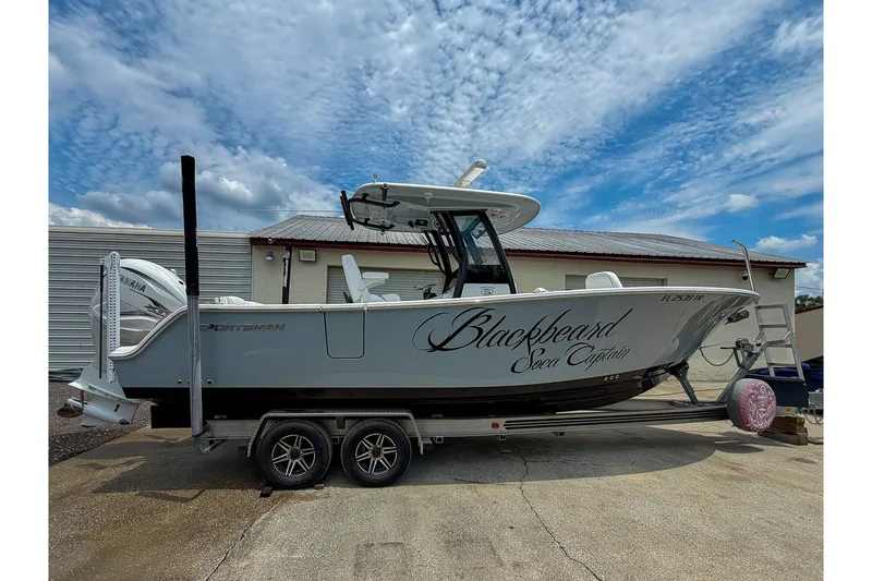 The Image of 2023 Sportsman Heritage 261 Center Console boat on trailer under cloudy sky. - 1