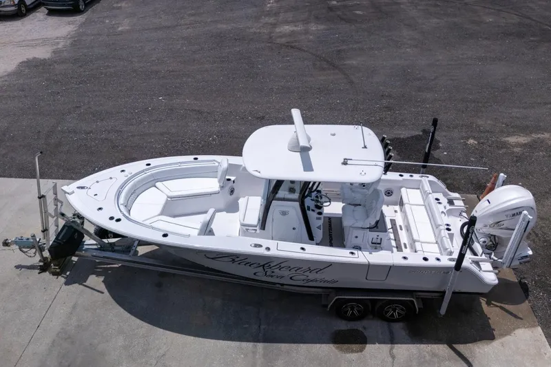 Slide: The Image of 2023 Sportsman Heritage 261 Center Console boat with Yamaha engine in a parking lot. - 104