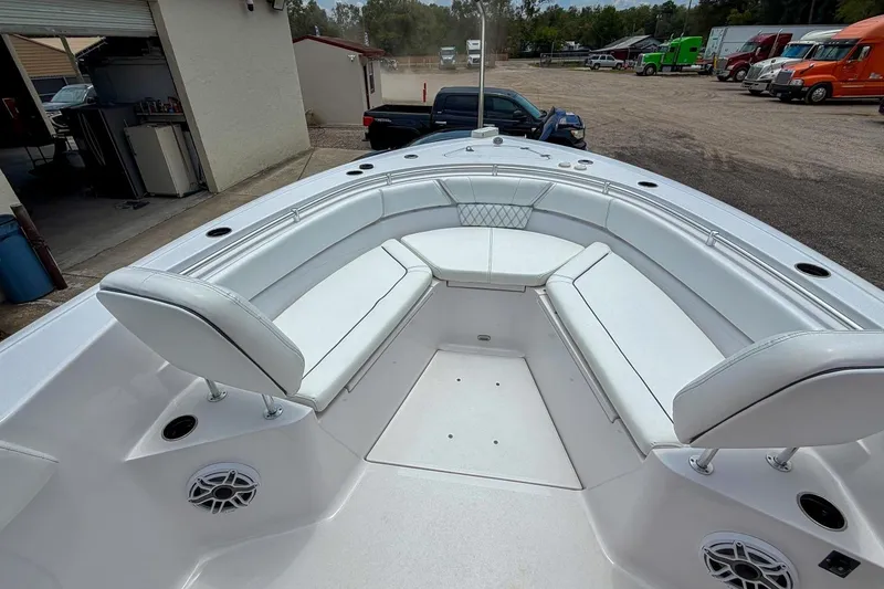 Slide: The Image of 2023 Sportsman Heritage 261 Center Console boat with open storage compartments, parked outdoors. - 19