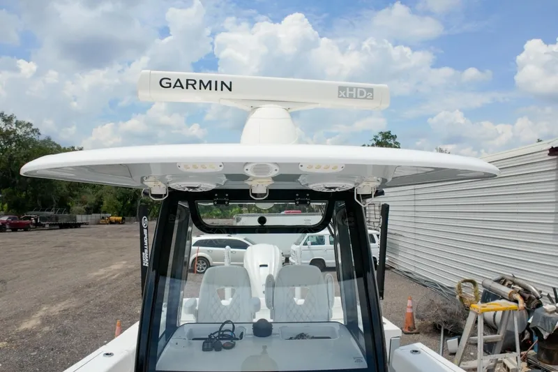 Slide: The Image of 2023 Sportsman Heritage 261 Center Console boat interior with white seating and storage. - 31