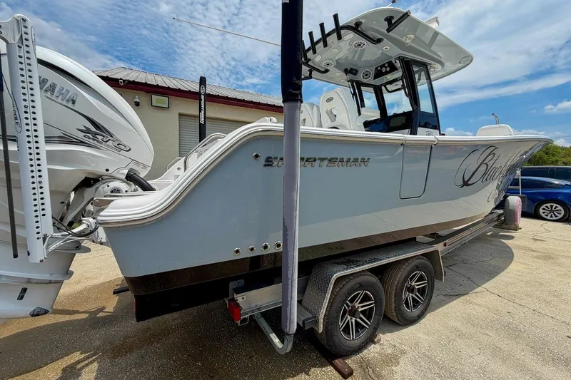 Slide: The Image of 2023 Sportsman Heritage 261 Center Console boat on trailer, under a partly cloudy sky. - 47
