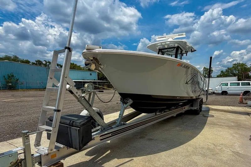 Slide: The Image of 2023 Sportsman Heritage 261 Center Console boat on trailer under a partly cloudy sky. - 53