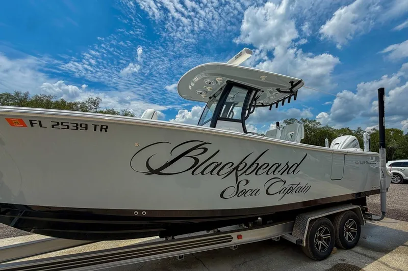 Slide: The Image of 2023 Sportsman Heritage 261 Center Console boat, rear view with logo, parked outdoors. - 55