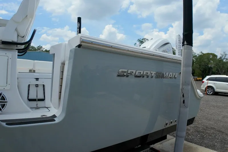 Slide: The Image of 2023 Sportsman Heritage 261 Center Console boat with logo, under a partly cloudy sky. - 56