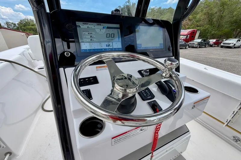 Slide: The Image of 2023 Sportsman Heritage 261 Center Console boat dashboard with modern controls and displays. - 6
