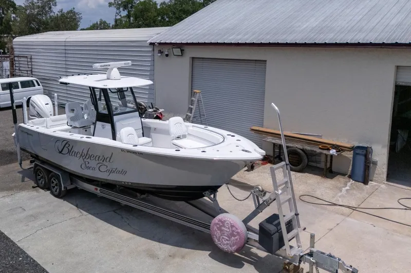 Slide: The Image of 2023 Sportsman Heritage 261 Center Console boat, aerial view, parked on concrete surface. - 99
