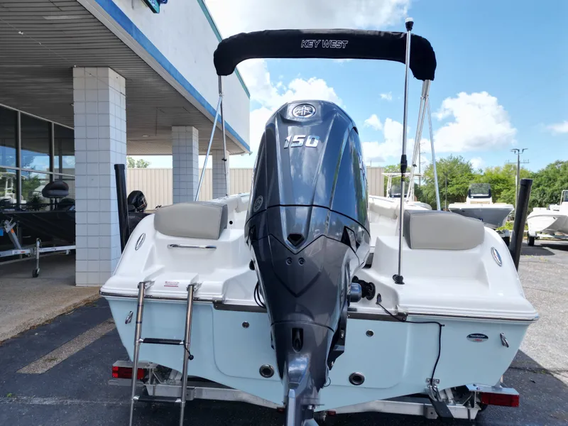 Slide: The Image of Key West 203 FS boat 2026 with outboard motor, parked outdoors. - 8