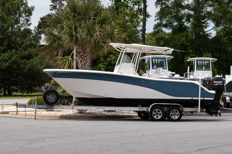The Image of 2010 Sea Fox 256 Center Console boat on trailer, parked near palm trees. - 0