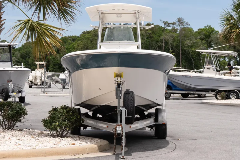 Slide: The Image of 2010 Sea Fox 256 Center Console boat on trailer, surrounded by palm trees and other boats. - 2