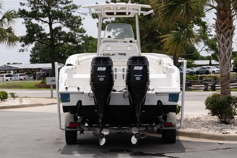 Slide: The Image of 2010 Sea Fox 256 Center Console boat with dual 150 horsepower engines, parked outdoors. - 4