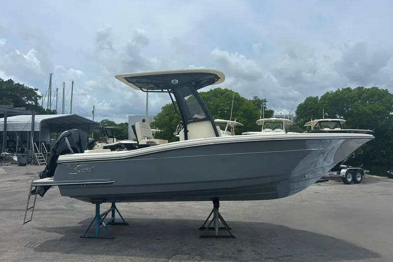The Image of 2026 Scout 220 XSF boat on stands, displayed outdoors under cloudy sky. - 0
