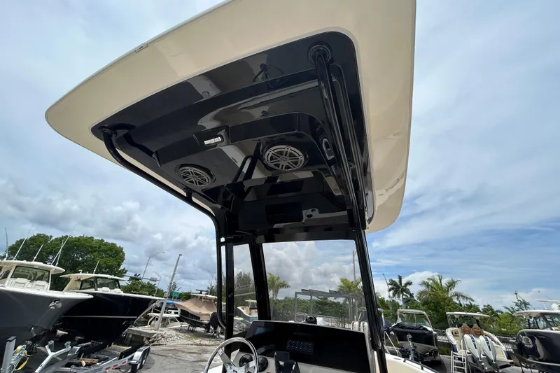 Slide: The Image of 2026 Scout 220 XSF boat with sleek T-top and integrated speakers, under a cloudy sky. - 3