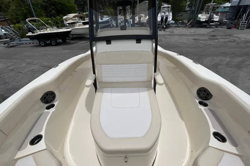 Slide: The Image of 2026 Scout 220 XSF boat interior with seating and cup holders, docked outdoors. - 7