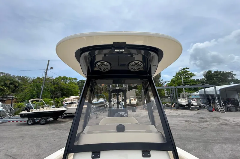 Slide: The Image of 2026 Scout 220 XSF boat with T-top and speakers, parked in a marina. - 8