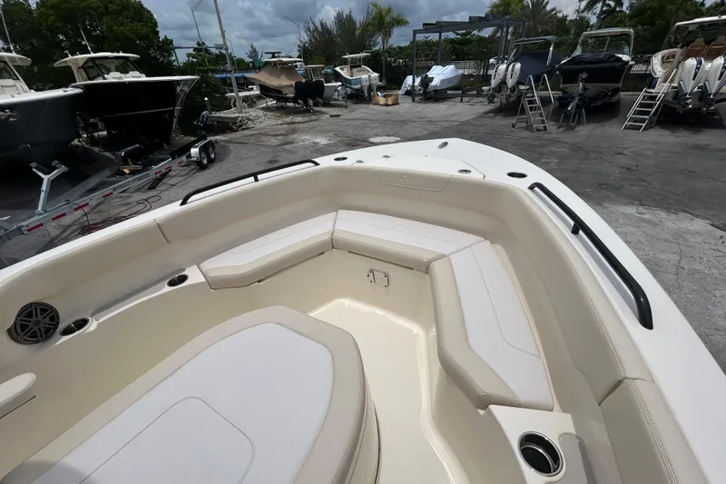 Slide: The Image of 2026 Scout 220 XSF boat interior with spacious seating and cup holders, docked outdoors. - 9