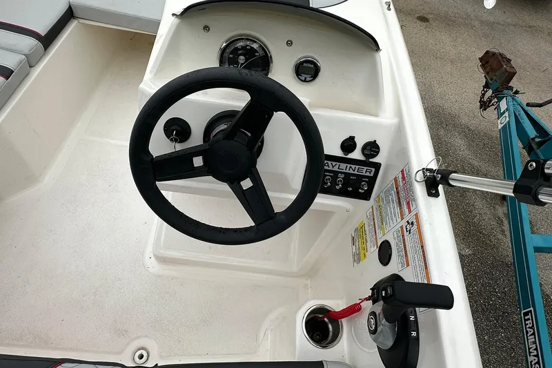 Slide: The Image of 2024 Bayliner Element M15 boat dashboard with steering wheel and control panel. - 10