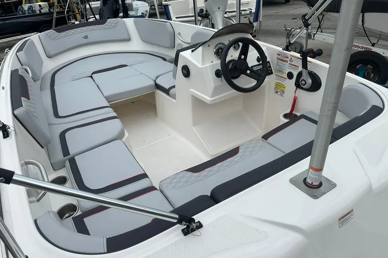 Slide: The Image of 2024 Bayliner Element M15 boat interior with gray seating and steering console. - 14