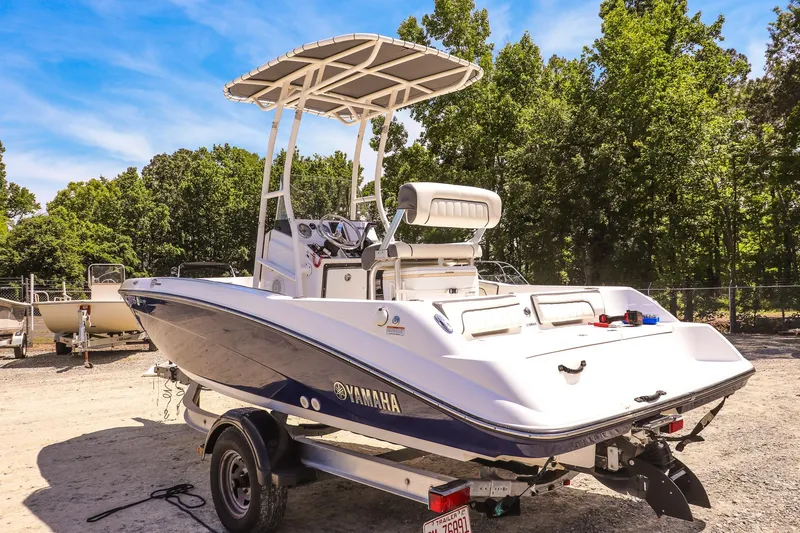Slide: The Image of 2017 Yamaha Boats 190 FSH Sport on trailer, parked outdoors with trees in background. - 5