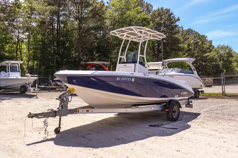 Slide: The Image of 2017 Yamaha Boats 190 FSH Sport on trailer, parked outdoors in a sunny setting. - 7