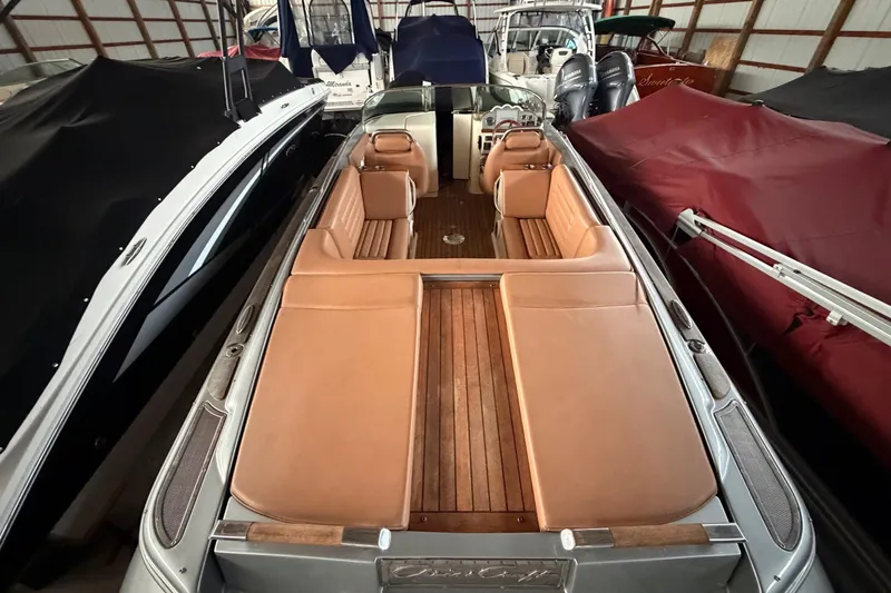 Slide: The Image of 2013 Chris-Craft Launch 25 boat with tan leather seats and wooden deck in storage. - 10