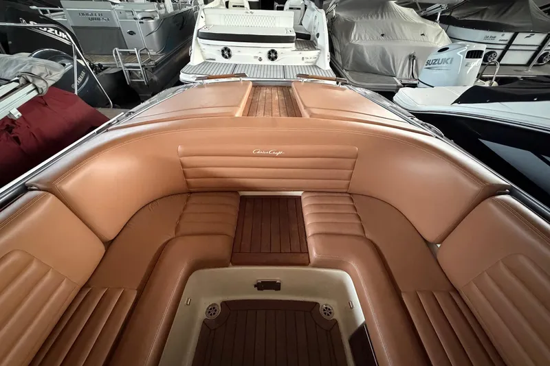 Slide: The Image of 2013 Chris-Craft Launch 25 boat interior with tan leather seating and wooden flooring. - 13