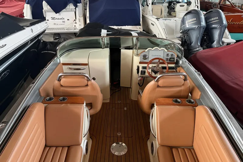 Slide: The Image of 2013 Chris-Craft Launch 25 boat interior with tan leather seats and wooden dashboard. - 18