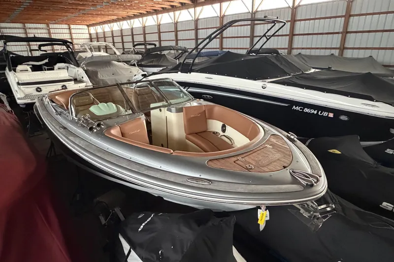 Slide: The Image of 2013 Chris-Craft Launch 25 boat in storage, surrounded by covered vessels. - 4