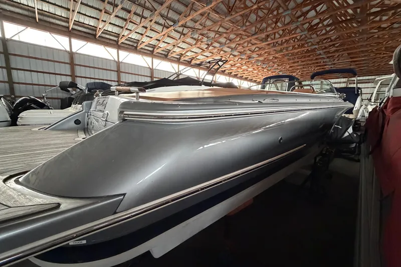 Slide: The Image of 2013 Chris-Craft Launch 25 boat in storage, showcasing sleek design and metallic finish. - 6
