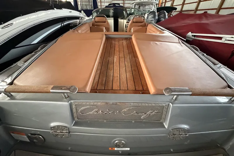 Slide: The Image of 2013 Chris-Craft Launch 25 boat with tan upholstery and wooden deck in storage. - 9
