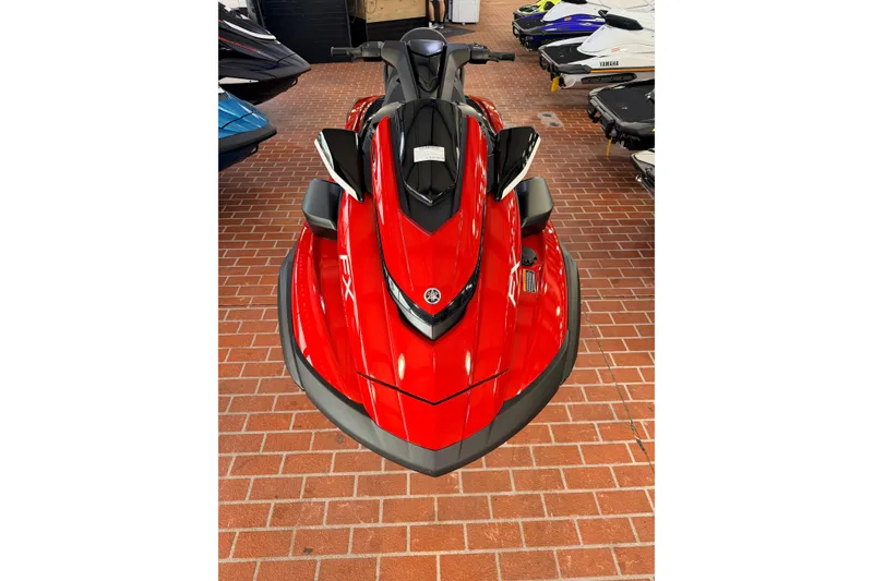 Slide: The Image of 2026 Yamaha WaveRunner FX Cruiser HO in vibrant red, displayed indoors on brick flooring. - 2