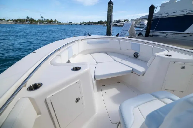 Slide: The Image of 2023 Robalo R302 Center Console boat interior with seating, docked by the water. - 20