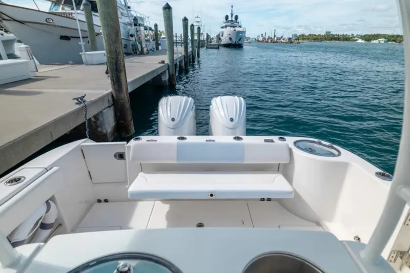 Slide: The Image of 2023 Robalo R302 Center Console boat docked, featuring dual engines and spacious seating. - 23