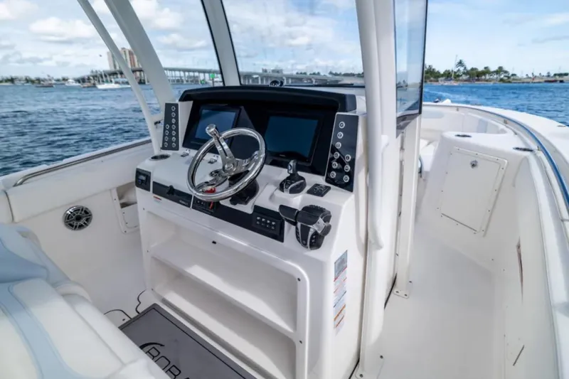 Slide: The Image of 2023 Robalo R302 Center Console boat interior with steering wheel and navigation screens. - 29