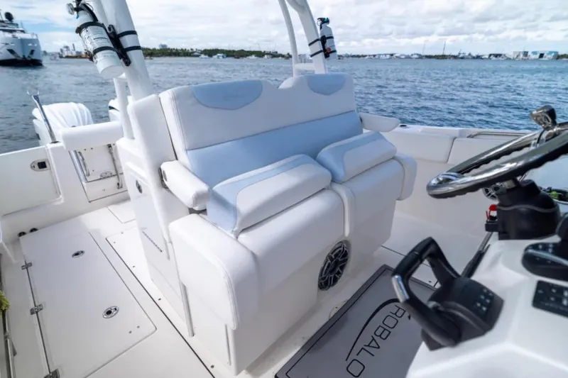 Slide: The Image of 2023 Robalo R302 Center Console boat interior with white seating and steering wheel. - 31