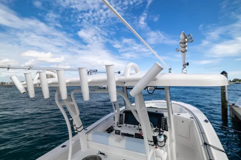Slide: The Image of 2023 Robalo R302 Center Console boat with rod holders, ocean view, and clear sky. - 33